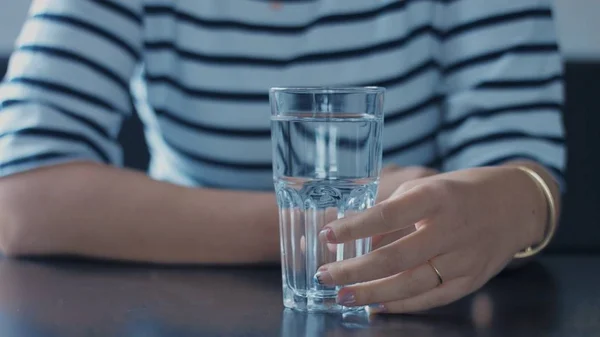 Primo piano delle donne mano con un bicchiere d'acqua — Foto Stock