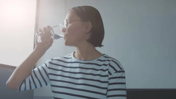 Frau in Top mit Streifen trinkt Wasser — Stockfoto