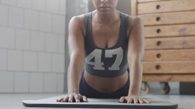 Genç zinde ve ses kadının yapması için güneşli çatı katında güç abs fitness egzersiz tahta elemanları ile yukarıya