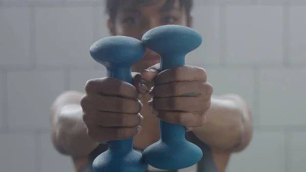 Retrato de mujer negra durante el entrenamiento con pesas primer plano con foucus en la mano con peso — Foto de Stock