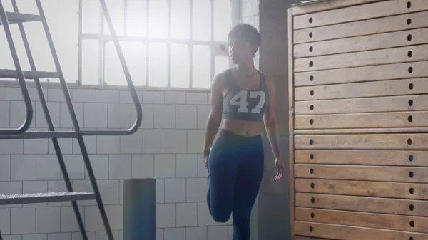 Jeune en forme et tonifier femme faisant le chauffage avant un entraînement de remise en forme dans un grenier ensoleillé — Photo