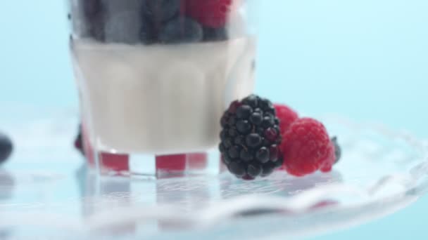 Bicchieri trasparenti pieni di yogurt, Panna Cotta, Mousse bianca alla vaniglia decorata con bacche — Video Stock