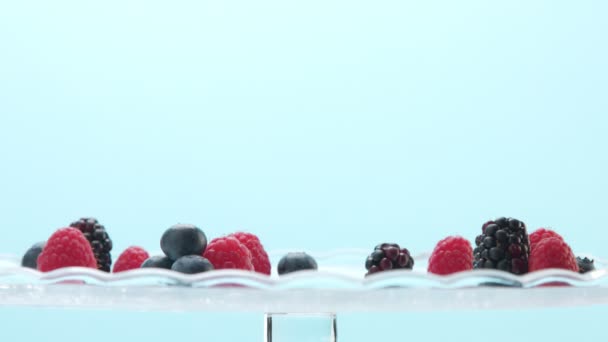 Transparent glasses full of yogurt, panna cotta, white vanilla mousse decorated with berries — Stock Video