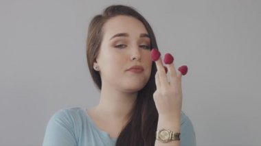 Ahududu parmaklarının arasından düz uzun saçlı genç Kafkas kadın yiyor