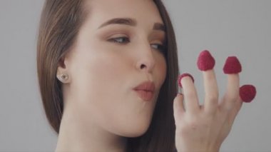 Ahududu parmaklarının arasından düz uzun saçlı genç Kafkas kadın yiyor