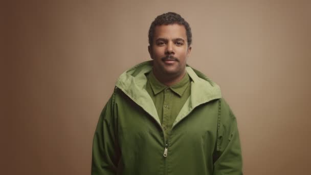 Hombre negro de raza mixta sobre fondo beige en retrato de estudio — Vídeos de Stock