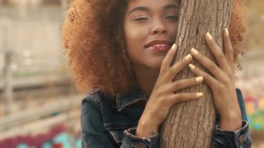 çim alan yüksek kuru sonbahar saman çim ve günbatımı ışığı ile büyük afro kıvırcık saçlı siyah karışık ırk kadın