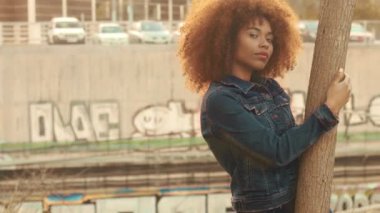 çim alan yüksek kuru sonbahar saman çim ve günbatımı ışığı ile büyük afro kıvırcık saçlı siyah karışık ırk kadın