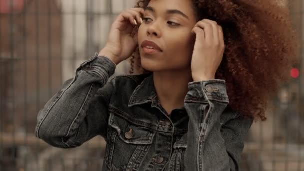 Svart blandad ras kvinna med stora afro lockigt hår i utomhus city — Stockvideo