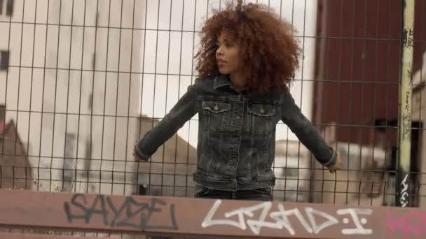 Mujer de raza mixta negra con gran pelo afro rizado en la ciudad al aire libre — Vídeo de stock