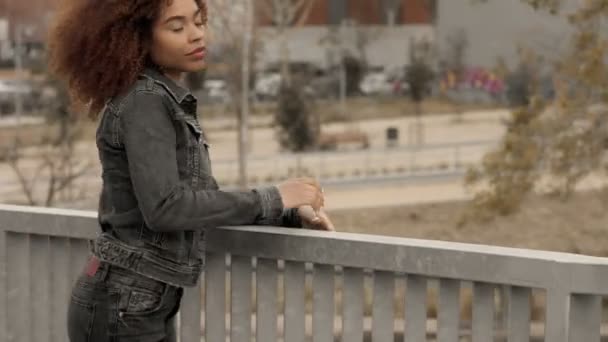 Zwart gemengd ras vrouw met grote afro krullend haar in buiten stad — Stockvideo