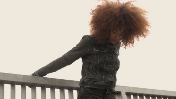 Mujer de raza mixta negra con gran pelo afro rizado en la ciudad al aire libre — Vídeos de Stock