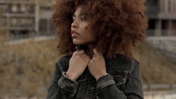 Черный смешанной расы женщина с большим афро кудрявые волосы в открытом городе — стоковое видео
