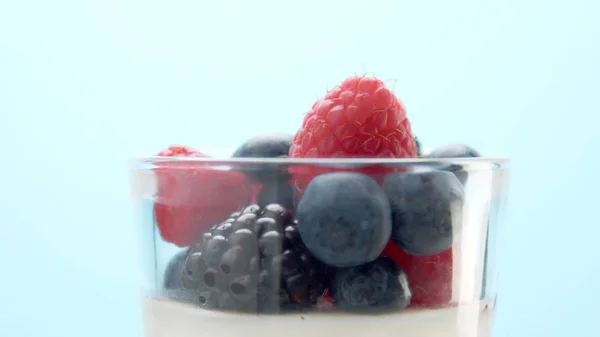 Transparent glasses full of yogurt, panna cotta, white vanilla mousse decorated with berries — Stock Photo, Image