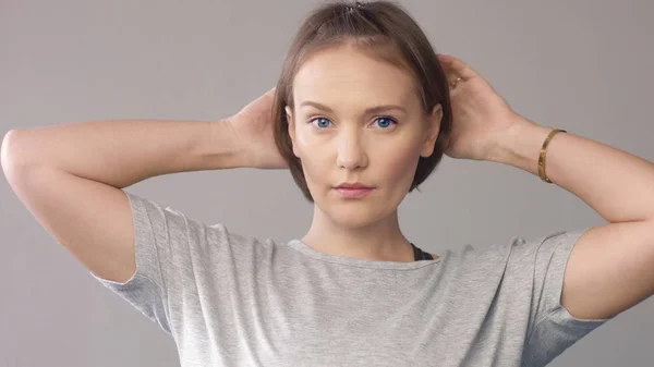 Gelukkig lachende vrouw over grijs — Stockfoto