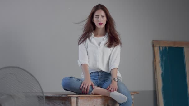 Woman in industrial studio wears jeans and white shirt — Stock Video