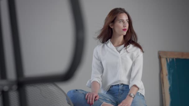 Woman in industrial studio wears jeans and white shirt — Stock Video