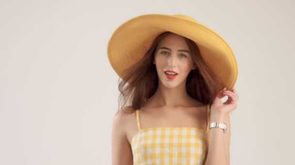 白い背景の上の黄色のトップで夏を見て女性モデル — ストック動画