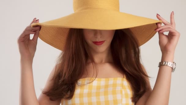 Primer plano retrato de la mujer con el pelo liso grande lleva sombrero de color amarillo de verano grande — Vídeos de Stock