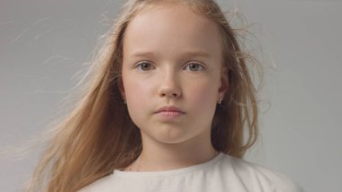 Stüdyoda genç bir kız, yakın plan gri portrede.