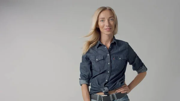 Blonde 30s woman alone in studio wears denim look — Stock Photo, Image