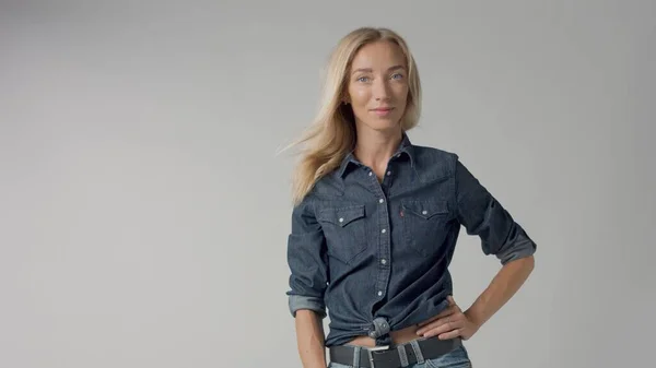 Blonde 30s woman alone in studio wears denim look — Stock Photo, Image