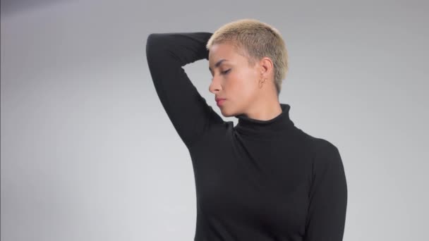 Blonde with short haircut in studio poses for camera on grey Ideal skin — Stock Video