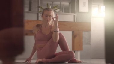Genç kadın kendi stüdyosunda yoga yapıyor.