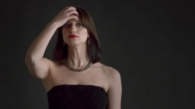 Siyah arka planda, gece makyajlı güzel 30 'lu yaşlarda bir kadın.