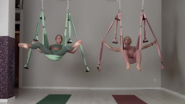 Deux professeurs de yoga aérien pendant une classe faisant des éléments de yoga aérien — Video