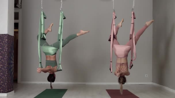 Dois professores aéreos de ioga durante uma aula fazendo elementos aéreos de ioga — Vídeo de Stock