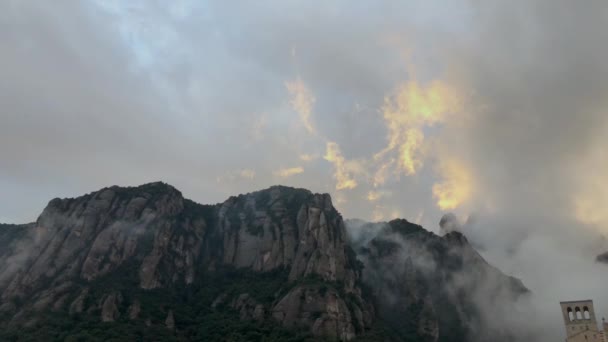 Sich schnell bewegende Wolken hinter dem Berggipfel im Sonnenaufgangslicht — Stockvideo