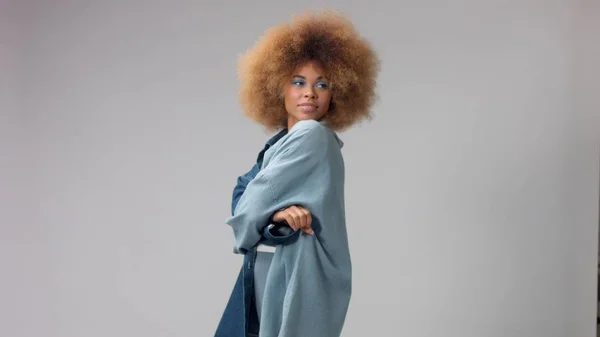 Retrato de mulher negra de raça mista com cabelo afro veste uma camisa denim oversize — Fotografia de Stock