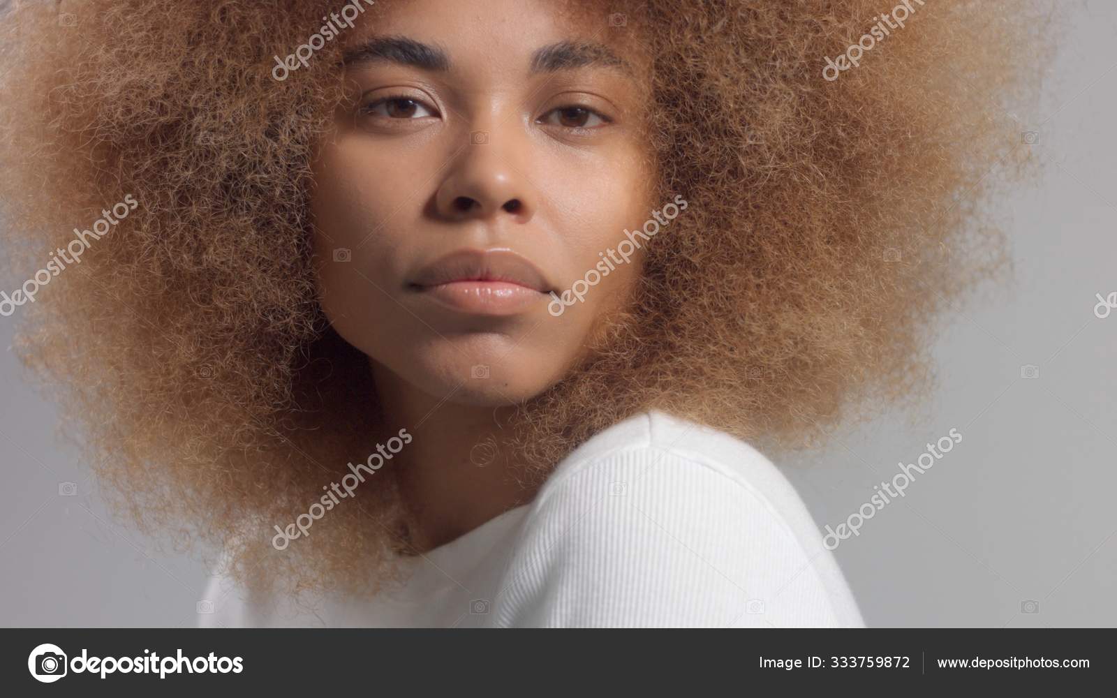 Mixed race black woman with big afro hair in studio put a cream smudge  Stock Photo by ©kazzakova 333759872