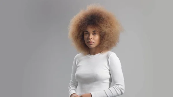 Змішана раса чорношкіра жінка з великим афро волоссям в студії поклала крем розмивання — стокове фото