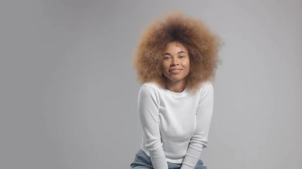 Gemengde race zwarte vrouw met grote afro haar in de studio zet een crème vlek — Stockfoto