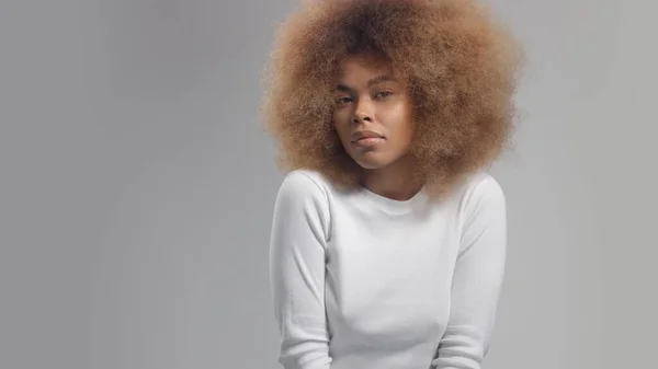 Wanita kulit hitam ras campuran dengan rambut afro besar di studio menempatkan noda krim — Stok Foto