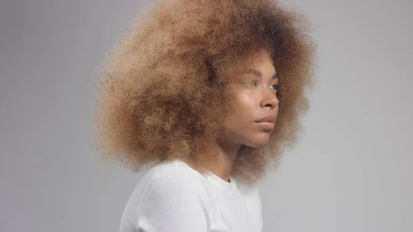 Mixta raza negro mujer con Grande afro cabello en estudio poner un crema mancha — Foto de Stock