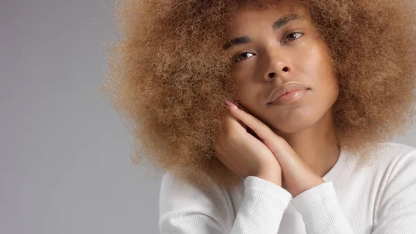 Gemengde race zwarte vrouw met grote afro haar in de studio zet een crème vlek — Stockfoto