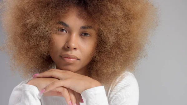 Черная женщина смешанной расы с большими афро-волосами в студии нанесла кремовое пятно — стоковое фото