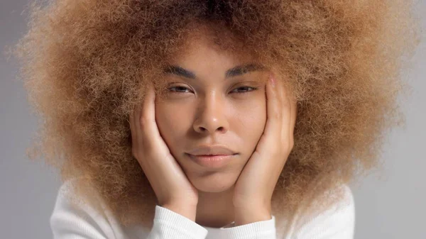 Mixed race black woman with big afro hair in studio put a cream smudge — Stock Photo, Image