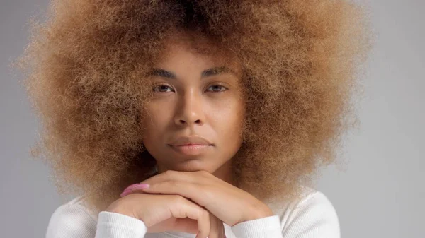 Gemengde race zwarte vrouw met grote afro haar in de studio zet een crème vlek — Stockfoto