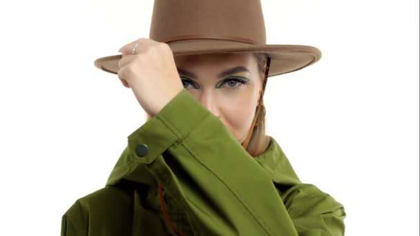 Mujer en un look otoñal en estudio en parka verde y sombrero gira y posa a la cámara — Vídeos de Stock