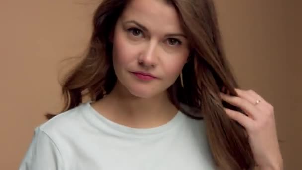 Монохромный натуральный макияж выглядеть белая женщина в студии с брюнеткой волнистые волосы дует — стоковое видео