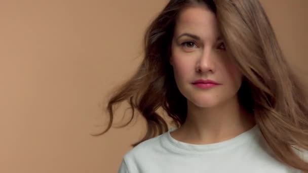 Monochrom natürliches Make-up aussehen kaukasische Frau im Studio mit brünetten welligen Haaren weht — Stockvideo