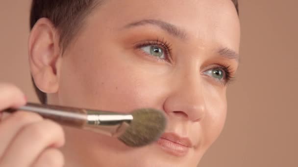 Kavkazská žena s krátkým účesem a přírodní béžové make-up ve studiu na béžovém pozadí — Stock video