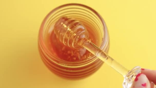 Closeup of honey spoon with pouring honey — Stock Video