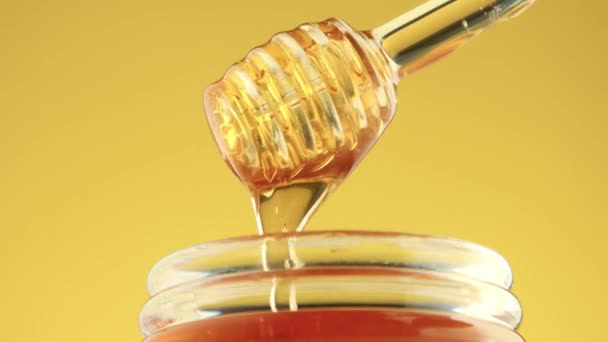 Closeup of honey spoon with pouring honey — Stock Video