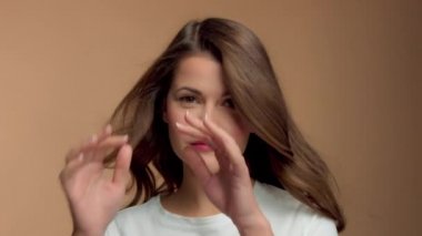Monochrome natural makeup look caucasian woman in studio with brunette wavy hair blowing