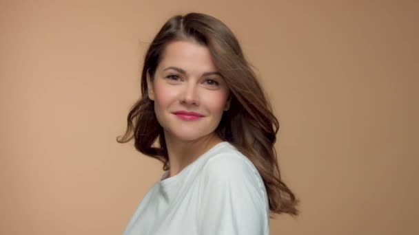 Monochrome natural makeup look caucasian woman in studio with brunette wavy hair blowing — 비디오